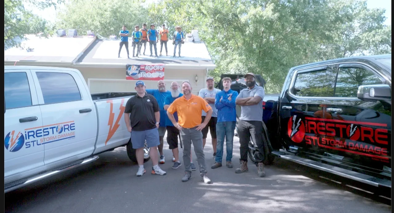 iRestore STL crew and owner Kirk Kupsky in front of branded trucks at a Roofs for Troops job site in the Belleville, IL area