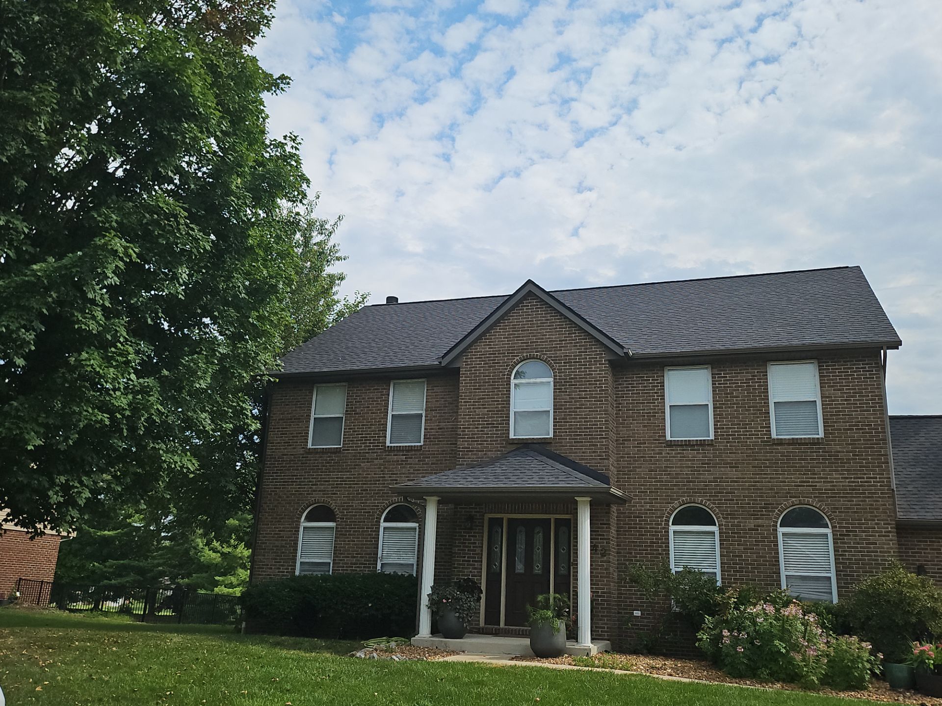Completed dark architectural shingle roof on a two-story brick colonial home in Belleville, IL