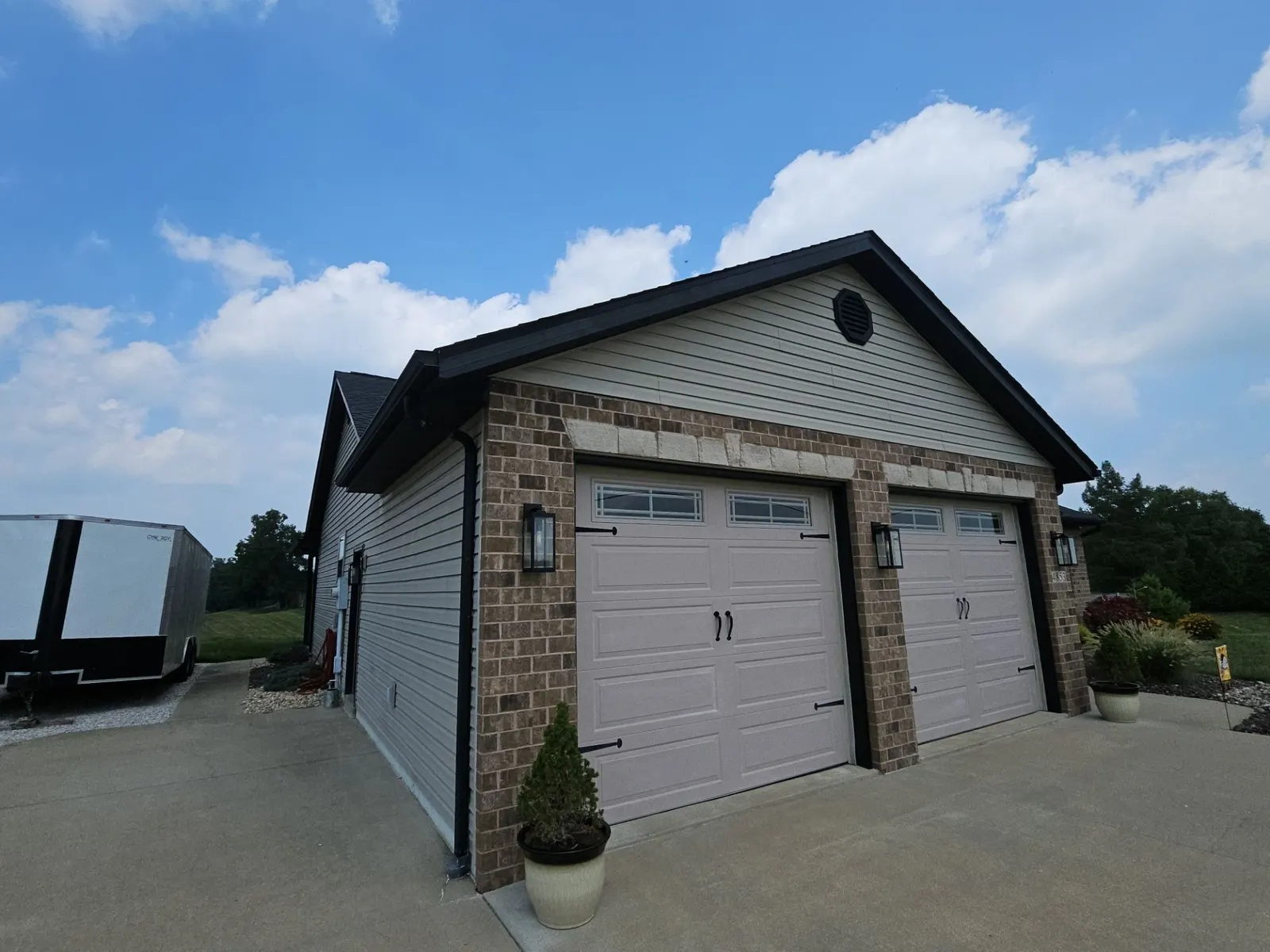 New dark shingle roof and black trim over a brick-front two-car garage in Aviston, IL