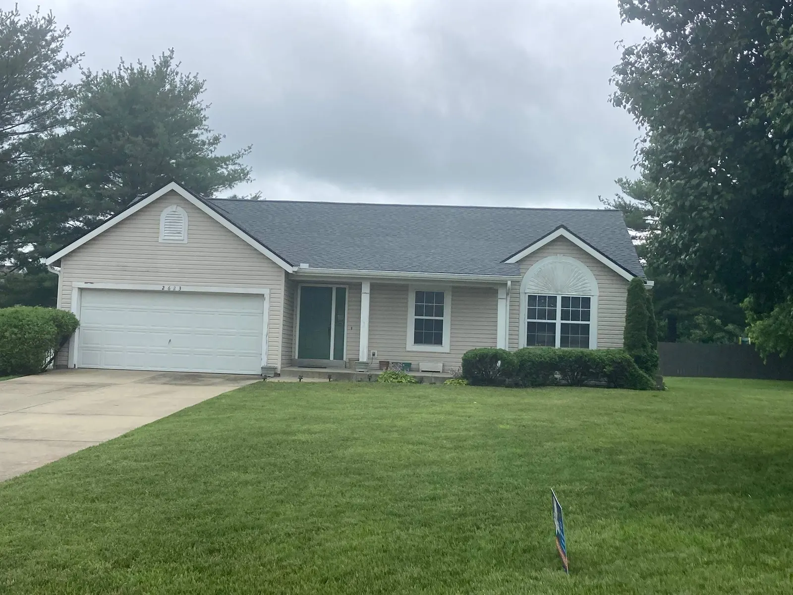 Finished shingle roof and white gutters on a tan ranch home in Columbia, IL