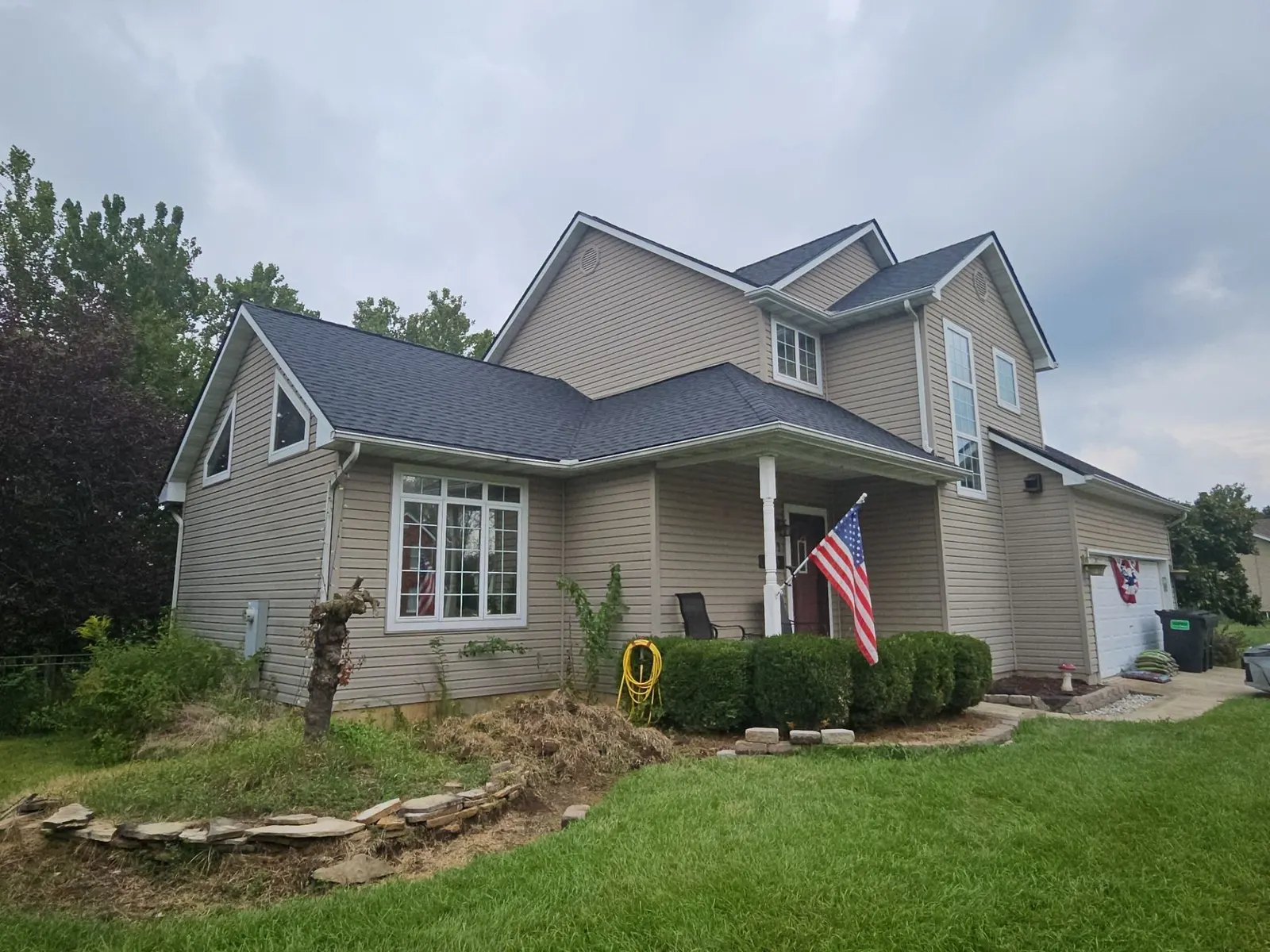 Side view of the finished charcoal shingle roof over the porch and main house of a two-story home in Fairview Heights, IL