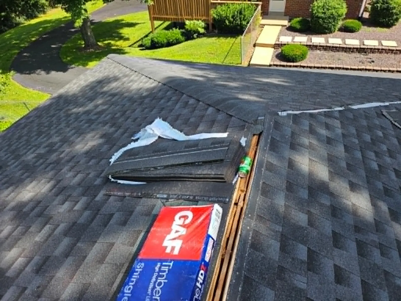 A bundle of GAF Timberline HDZ shingles on a roof partway through installation