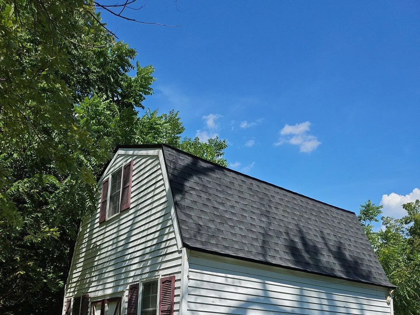 New charcoal shingle roof on a white-sided gambrel-style outbuilding in Maryville, IL